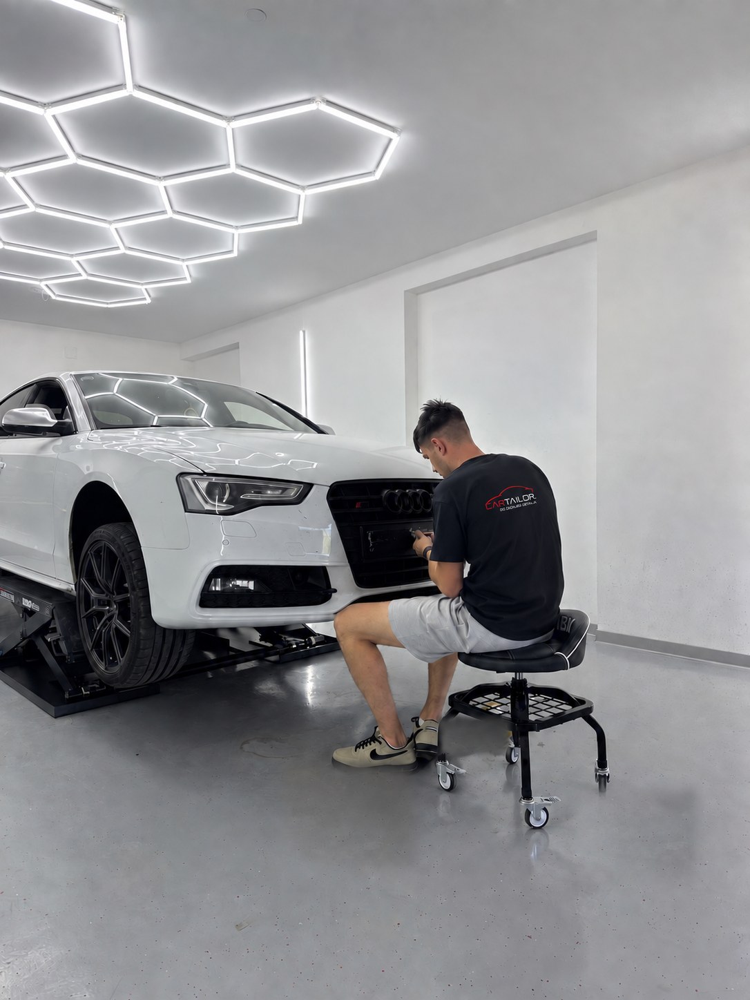 Marko u Car Tailor majici obnavlja far Audija u studiju.