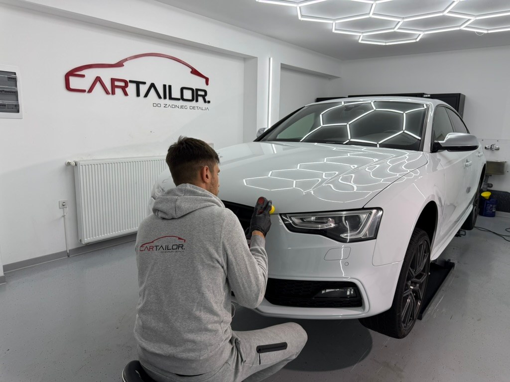 Marko u sivoj Car Tailor duksi radi na bijelom Audiju u svom studiju.